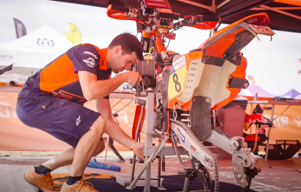 Servicing a KTM 450 factory rally motorcycle mid-race