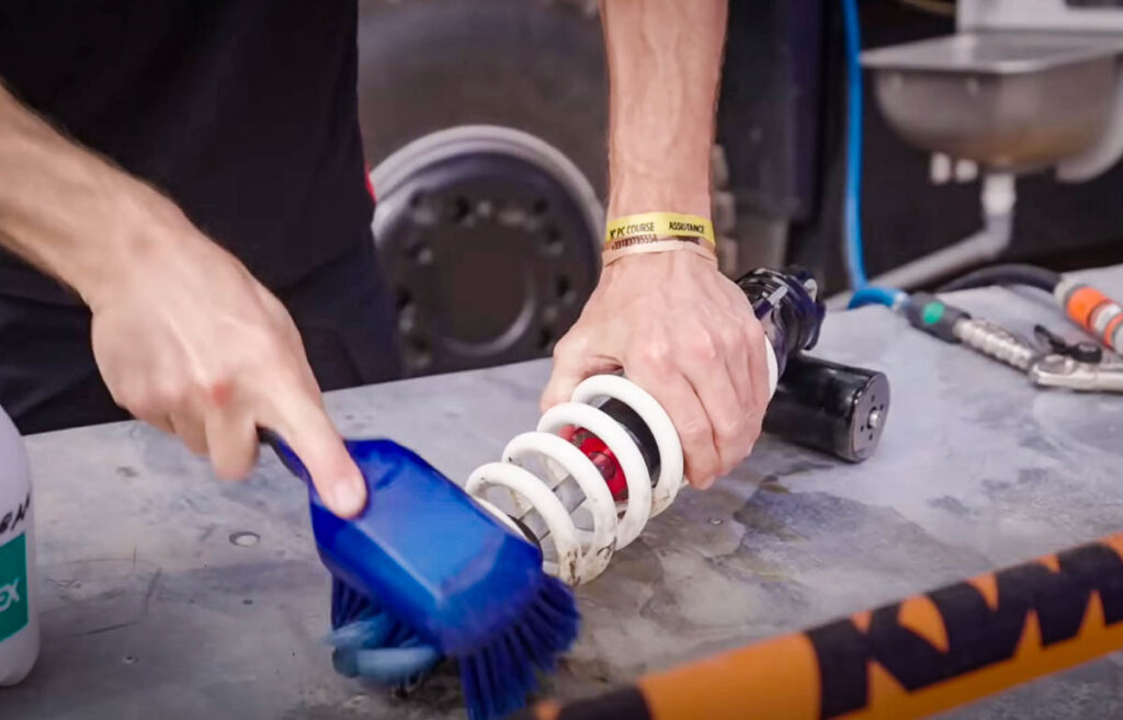 Servicing a KTM 450 factory rally motorcycle mid-race