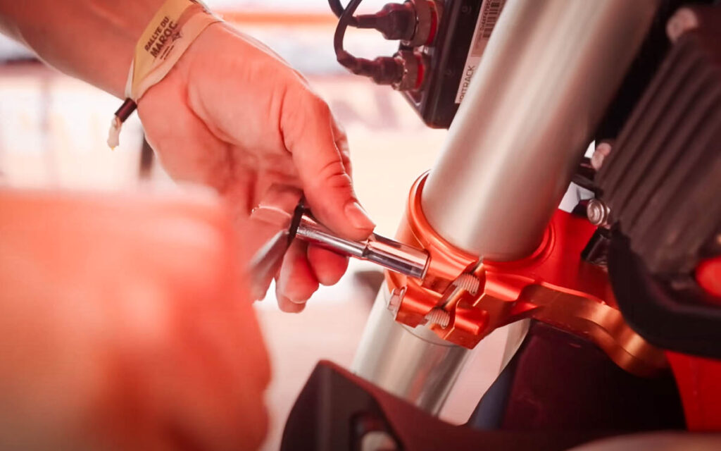 Servicing a KTM 450 factory rally motorcycle mid-race