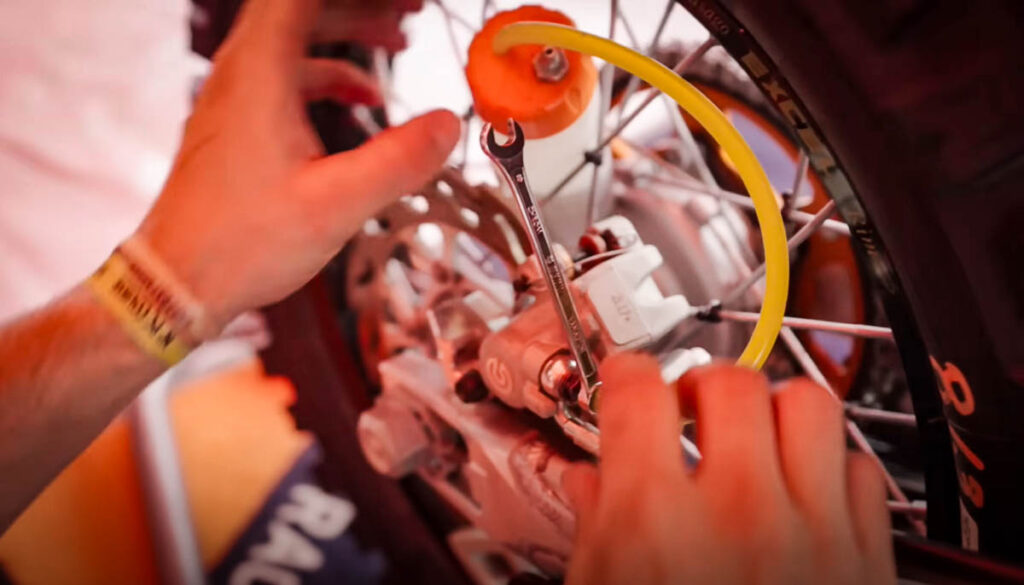 Servicing a KTM 450 factory rally motorcycle mid-race
