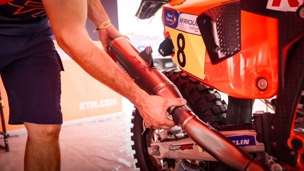 Servicing a KTM 450 factory rally motorcycle mid-race