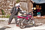 Simon Gandolfi riding a TVS 125 up to a Himalayan Pass